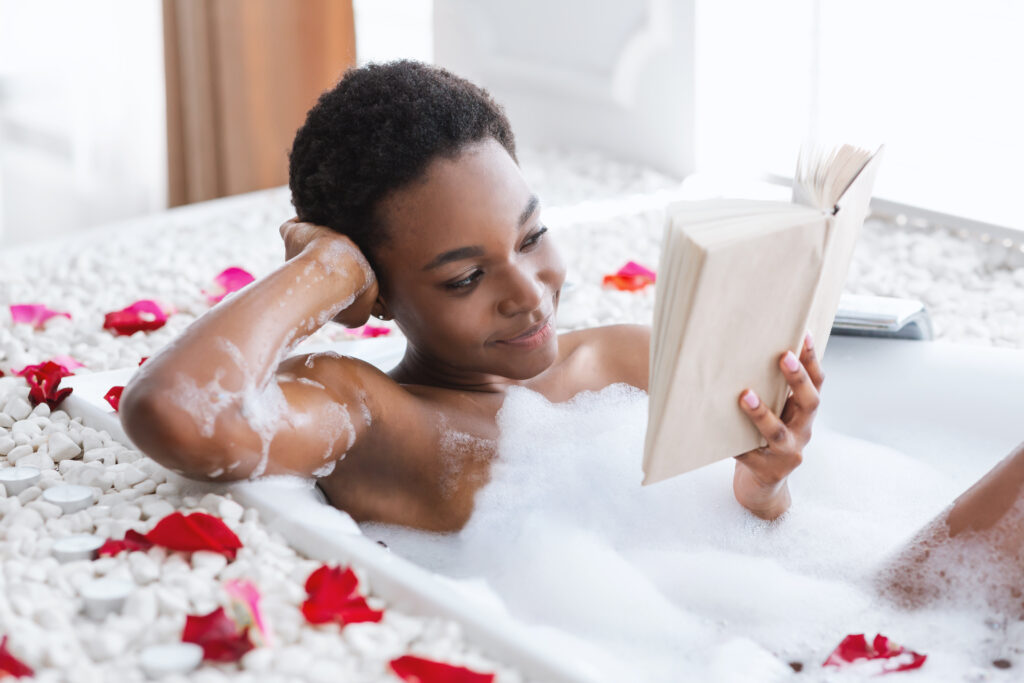 Woman enjoying bubble bath and reading.