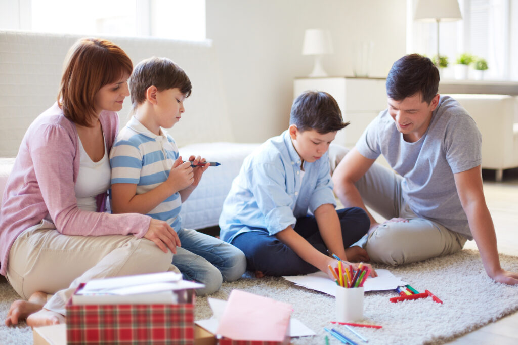 Family gathers to create a goal setting vision board for the new year.