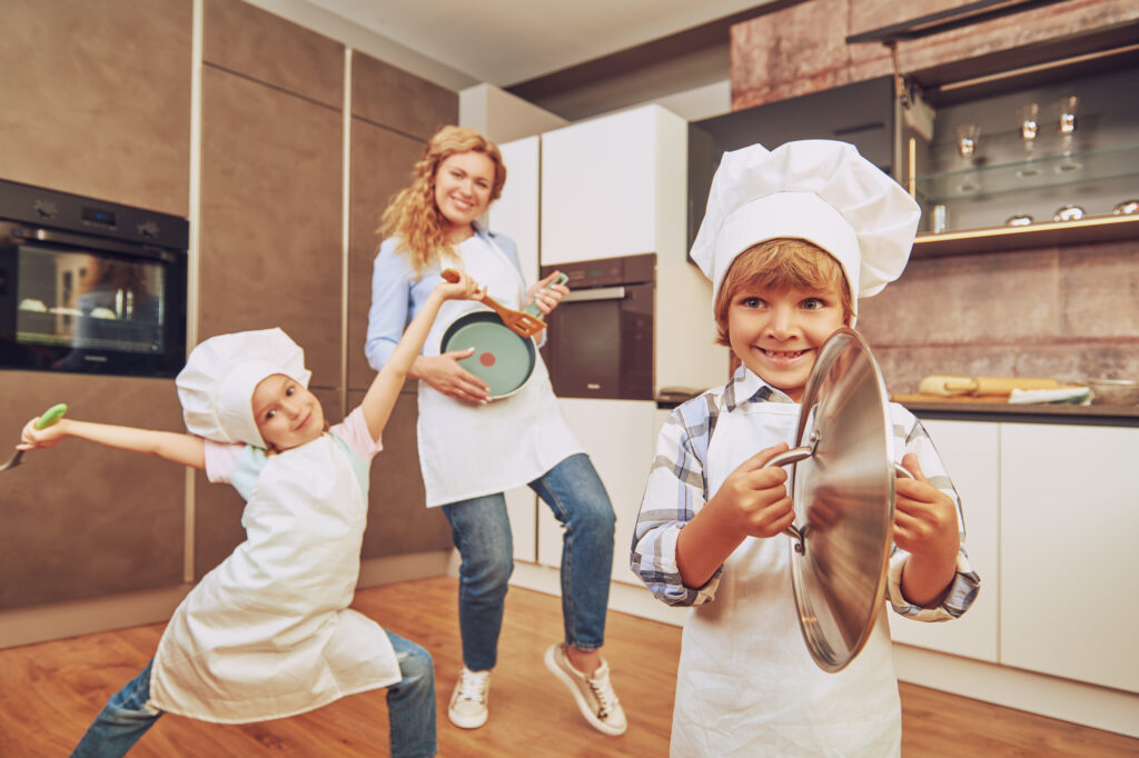 Mom and kids having fun singing in kitchen