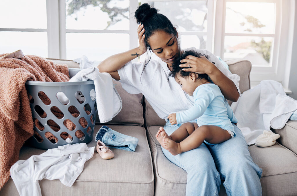 Tired Mom with baby and basket of laundry.